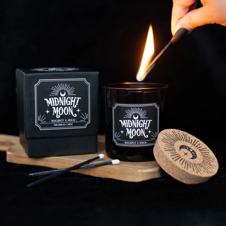 Świeca „Midnight Moon” o zapachu bergamotki i neroli w czarnym szkle z korkowym wieczkiem. Czas palenia ok. 21 h. Elegancka, gotycka, część kolekcji Midnight Rituals – idealna do relaksu i nastrojowych rytuałów.