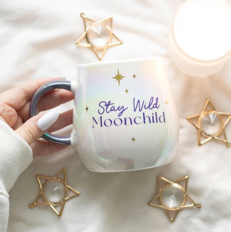 Opalizujący biały kubek „Stay Wild Moonchild” z motywem gwiazd i złotym napisem, pojemność 500 ml.