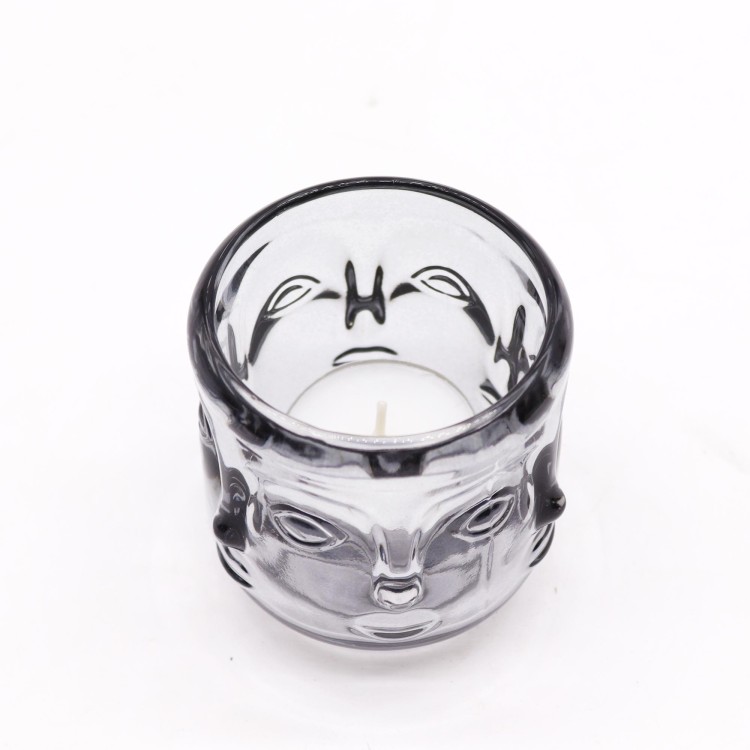 Szklany świecznik Twarze Buddy w odcieniu szarości północy, przeznaczony na tealighty. Minimalistyczny design z motywem Buddy, idealny do wnętrz w stylu zen, loftowych, SPA i przestrzeni medytacyjnych.