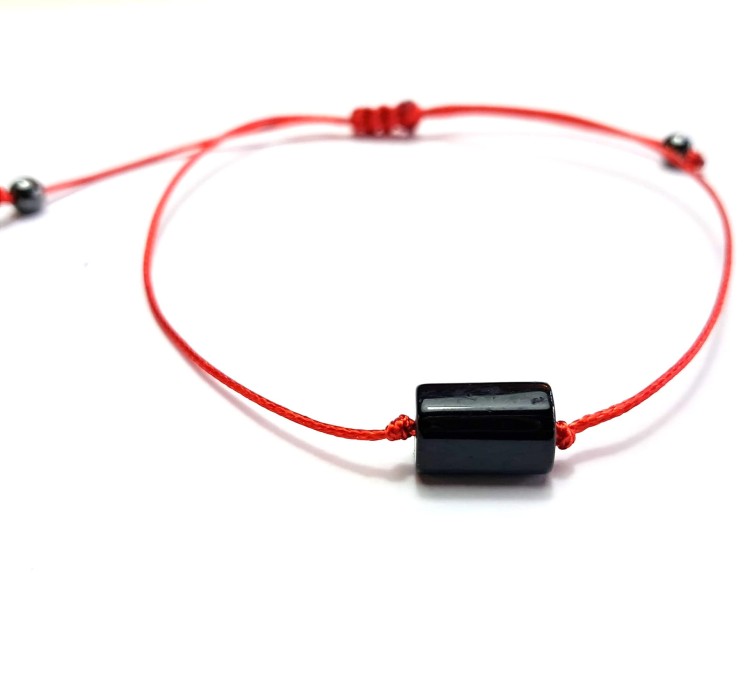 Bransoletka z polerowanym czarnym turmalinem na czerwonym sznurku. Ręcznie robiona w Polsce, chroni aurę, uziemia, wzmacnia energię i dodaje odwagi.