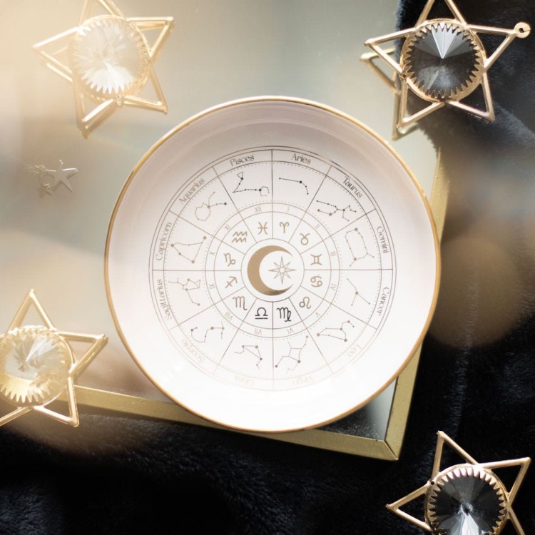 Misa zodiakalna ze złotym wykończeniem na tle dekoracji astrologicznych