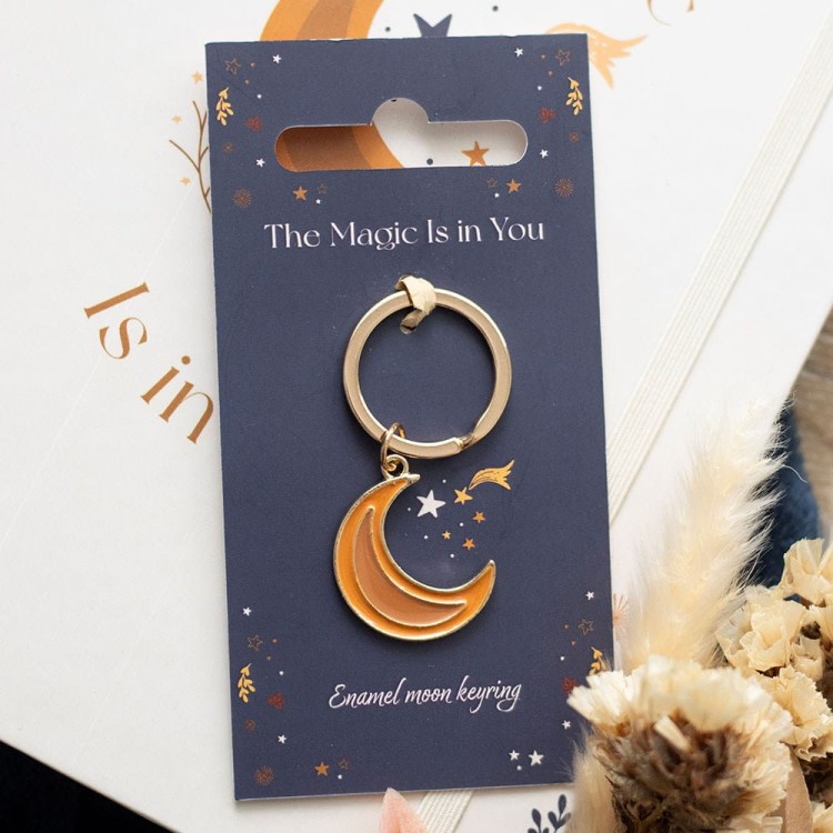 Enamel Moon Keyring – pomarańczowo-złoty brelok na tle z motywem gwiazd