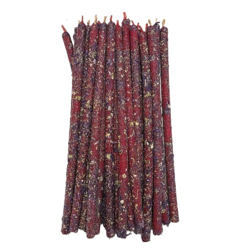 Cienkie czerwono–fioletowe świece rytualne pokryte suszoną szałwią.