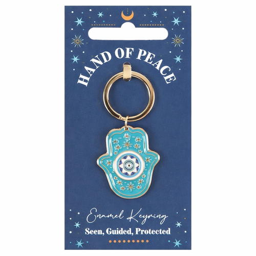 Turkusowy breloczek w kształcie dłoni Hamsy z okiem ochronnym, na granatowej karcie z napisem „Seen, Guided, Protected”.